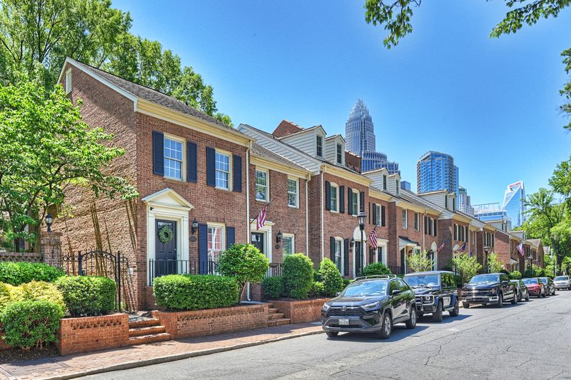 The brick rowhouse row at 520 N Poplar with the Uptown skyline beyond