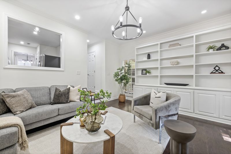 Living room with white built-ins and a pass-through to the kitchen